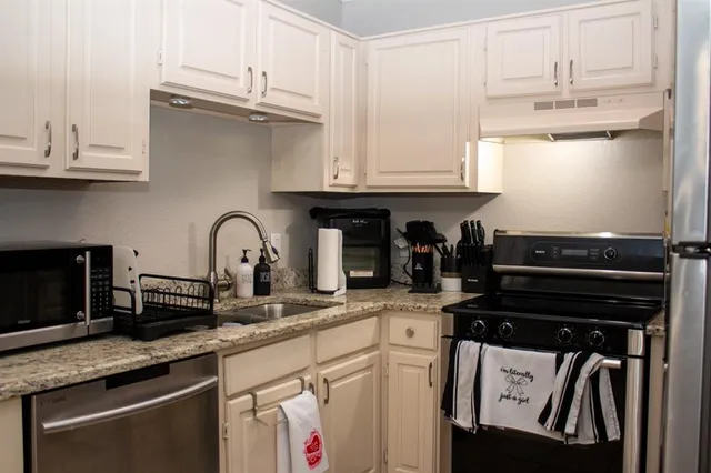 a kitchen with granite countertop a stove and cabinets