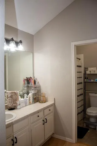 a bathroom with a granite countertop sink a toilet and shower