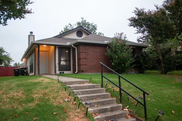a view of a house with brick walls and a small yard
