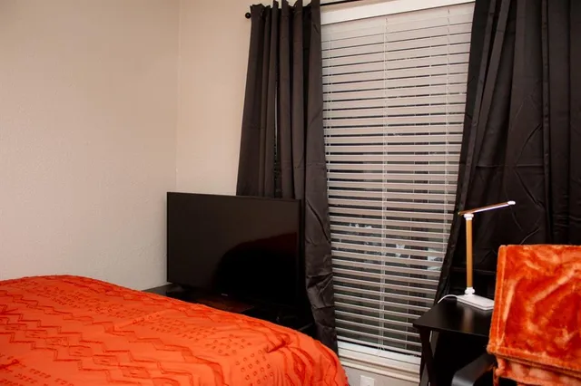 a blue bed sitting in a bedroom next to a window