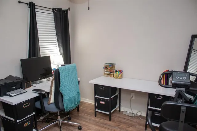 a view of a workspace with furniture and a window