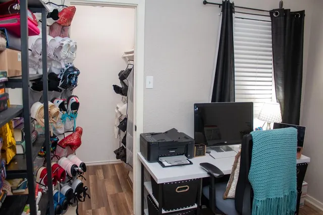 a view of a workspace with furniture and a window