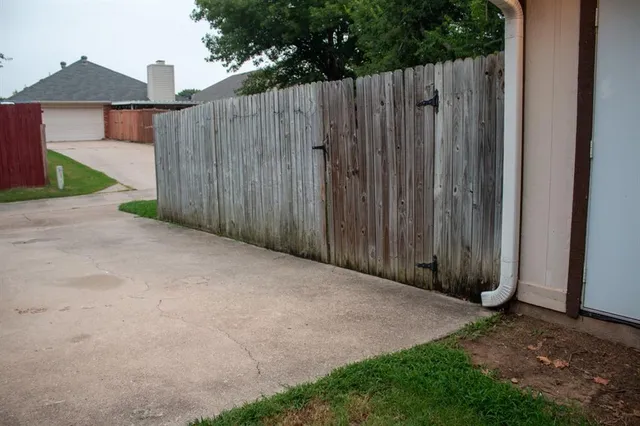 a view of a backyard with wooden fence
