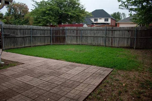 a view of a backyard with a wooden fence