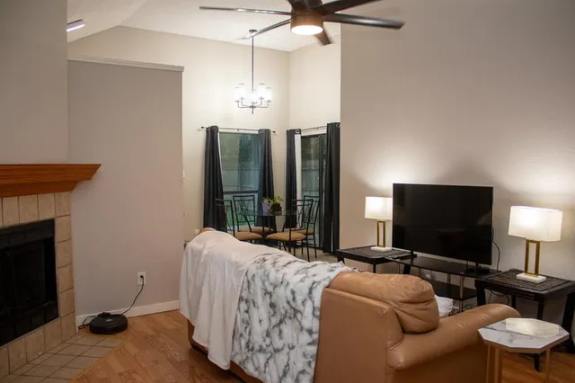 a living room with furniture a lamp and a flat screen tv