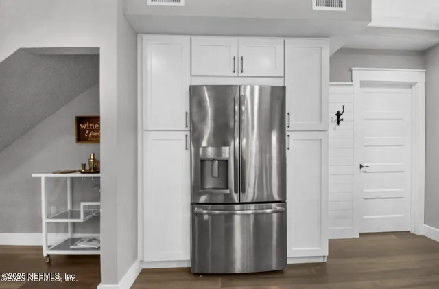 a view of kitchen with refrigerator and wooden floor