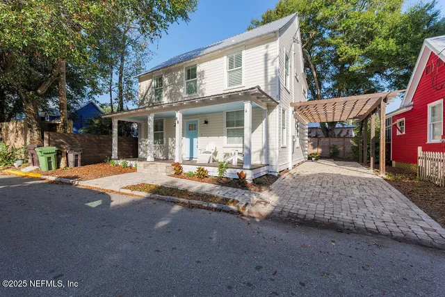 a view of a white house with a chairs in a patio