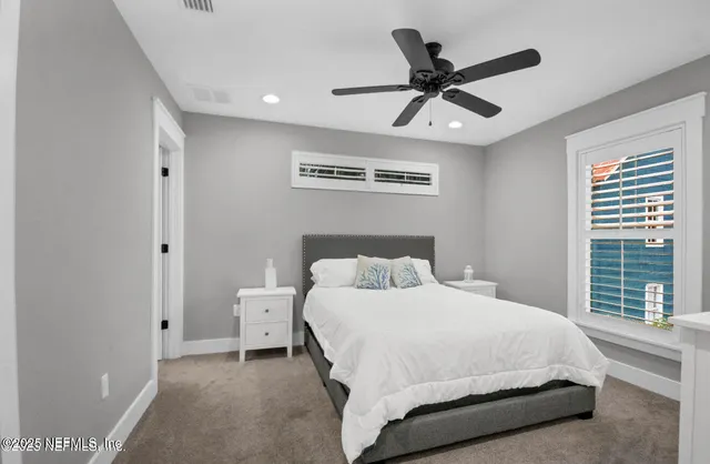 a bedroom with a large bed and a ceiling fan