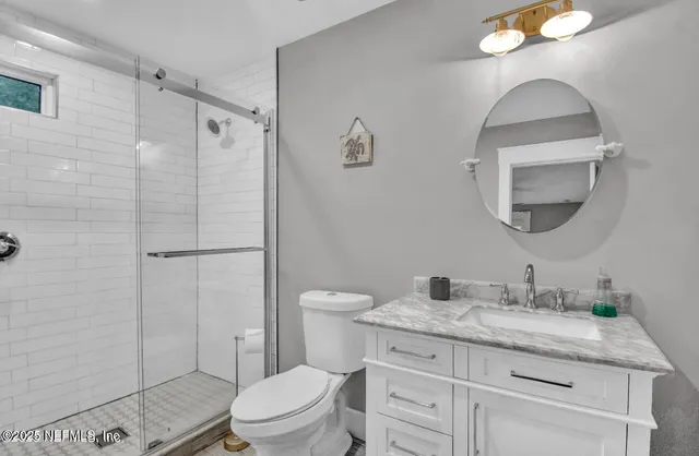 a bathroom with a granite countertop toilet a sink and mirror