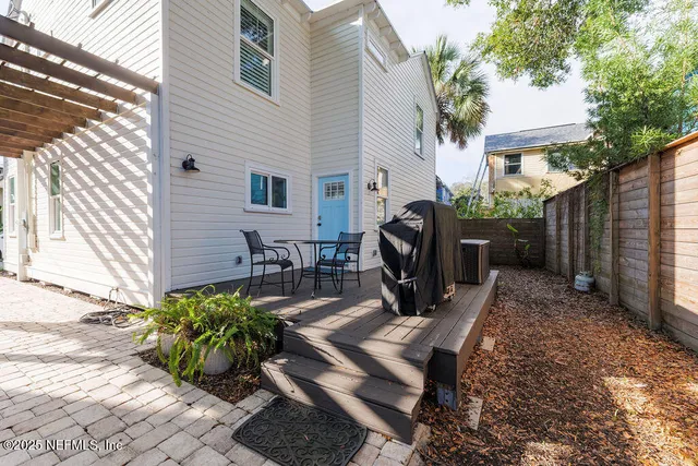 a view of a backyard with chairs potted plants and a wooden fence