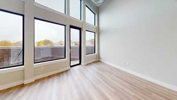 an empty room with wooden floor and door