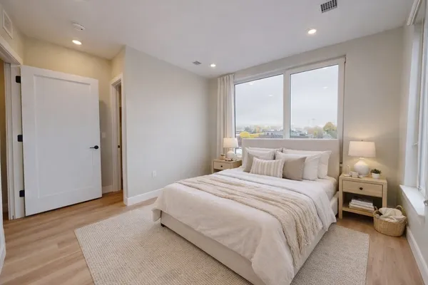 a bedroom with a large bed and a large window