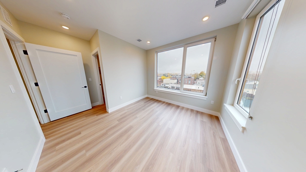 211 Green Street, Unit 509 Boston, MA 02130 - Photo 9 of 20 wooden floor in an empty room with a window
