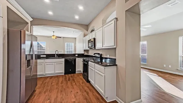 a kitchen with stainless steel appliances granite countertop a refrigerator and a stove top oven