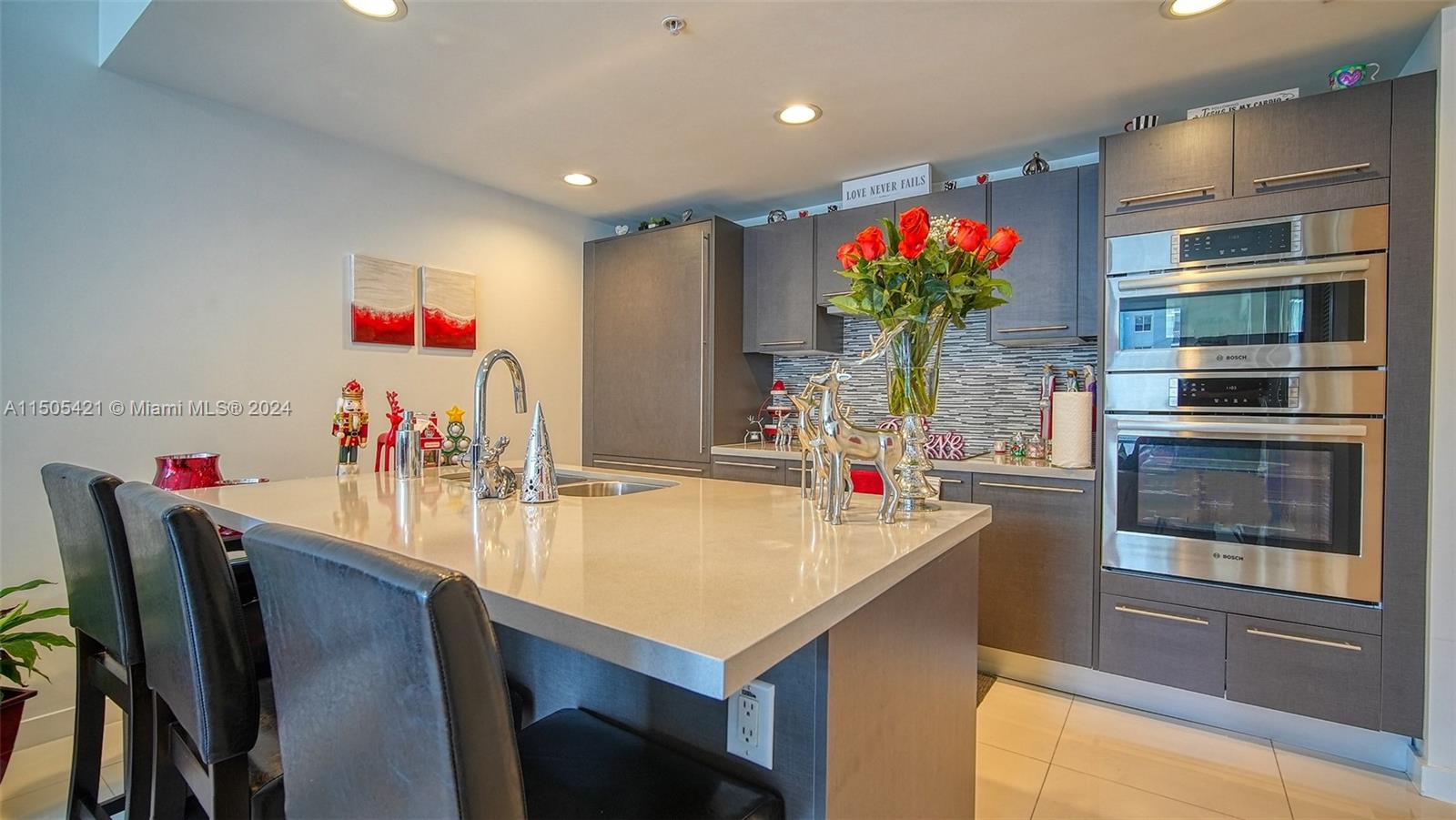 a room with stainless steel appliances kitchen island granite countertop a dining table and chairs with wooden floor