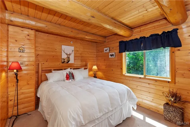 a bedroom with a bed a dresser and a window