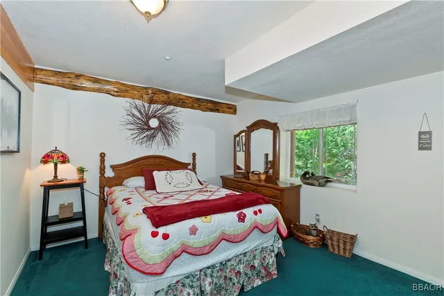 a bedroom with a bed and a dresser next to a window