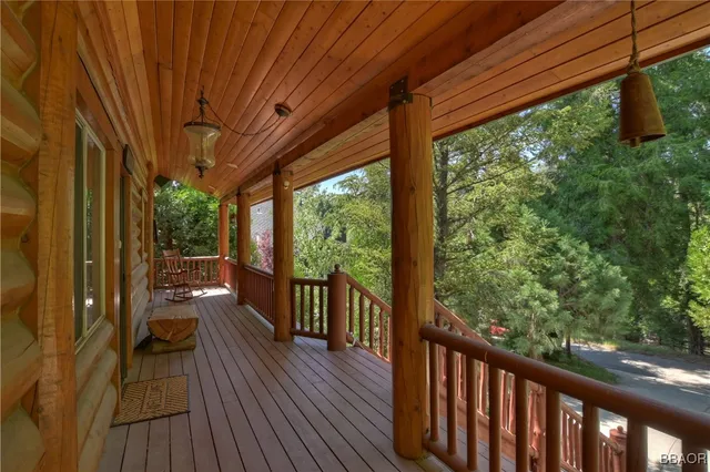 a balcony with wooden floor and outdoor seating