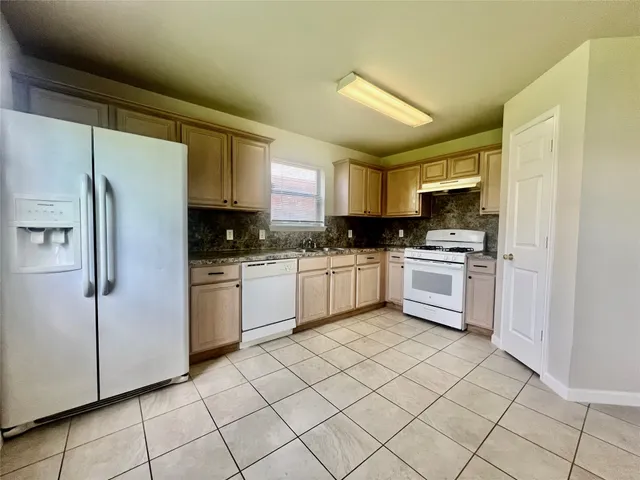 a kitchen with white cabinets stainless steel appliances and a window