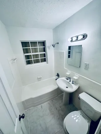 a bathroom with a sink toilet a mirror and bathtub
