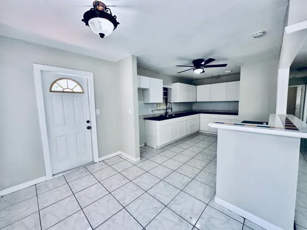 a kitchen with a refrigerator and white cabinets