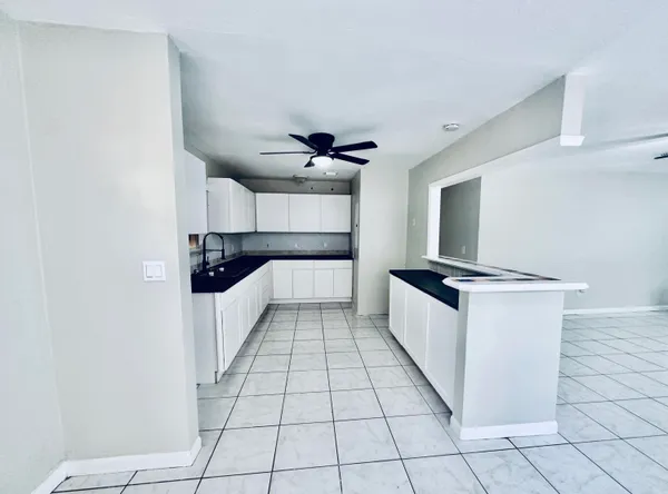 a large white kitchen with a stove a sink and a refrigerator