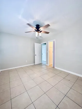 a view of an empty room and a ceiling fan