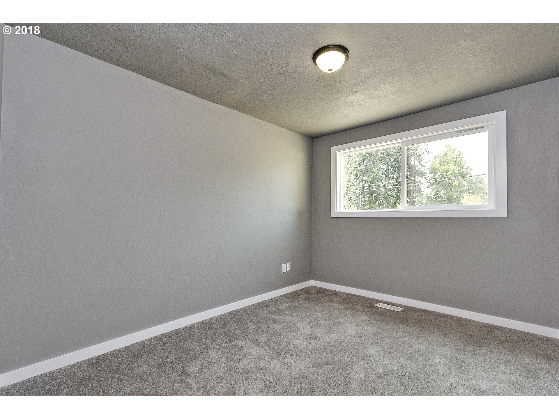 19818 Leland Road Oregon City, OR 97045 - Photo 6 of 11 a view of an empty room with wooden floor and windows