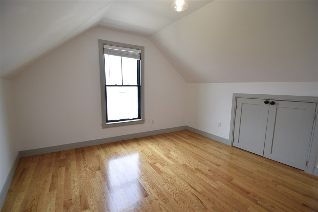 15 Maywood Street, Unit 4 Boston, MA 02119 - Photo 13 of 14 an empty room with wooden floor and windows