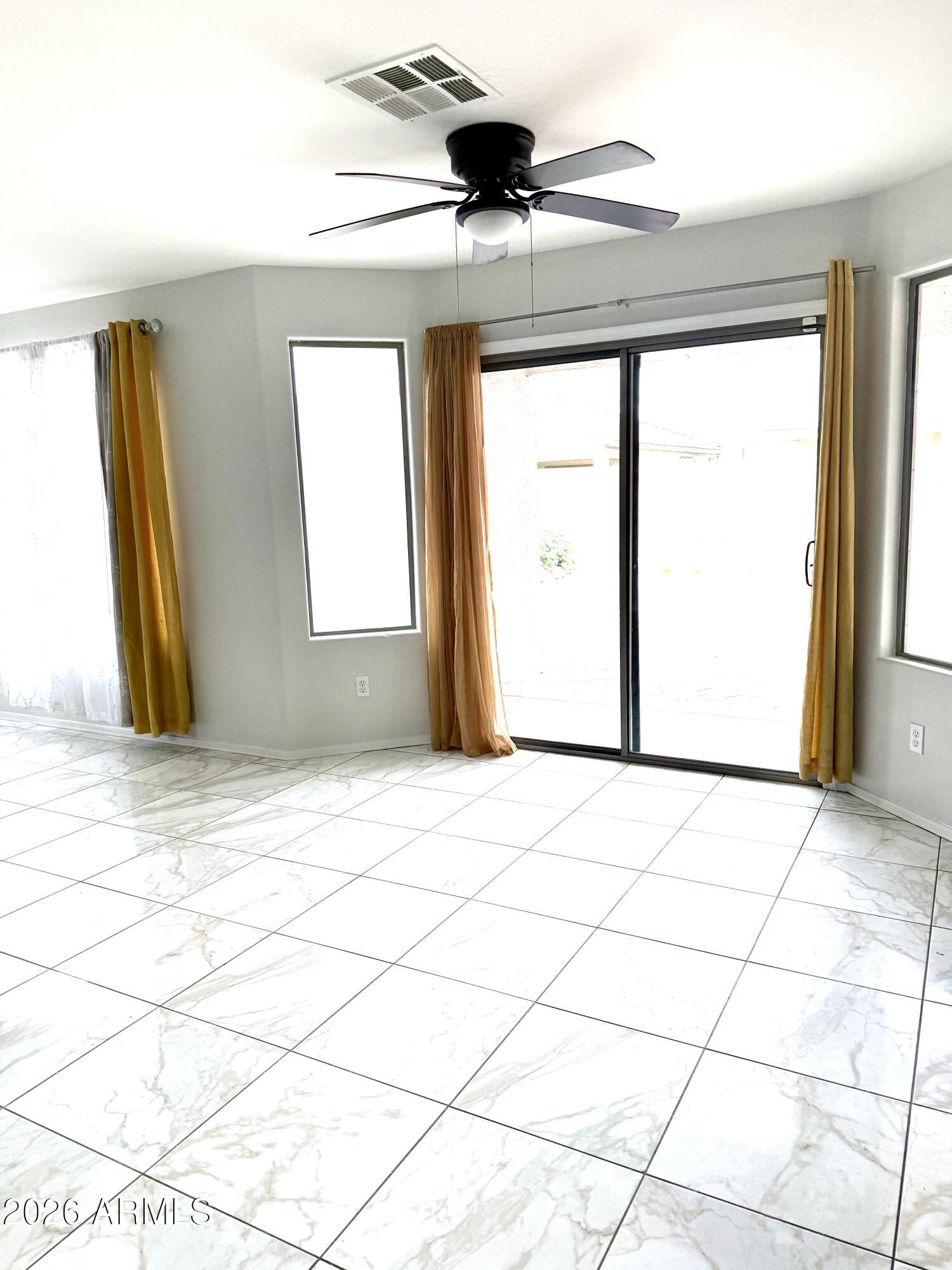 2326 West Gaby Road Phoenix, AZ 85041 - Photo 17 of 75 a view of an empty room with wooden floor and a window
