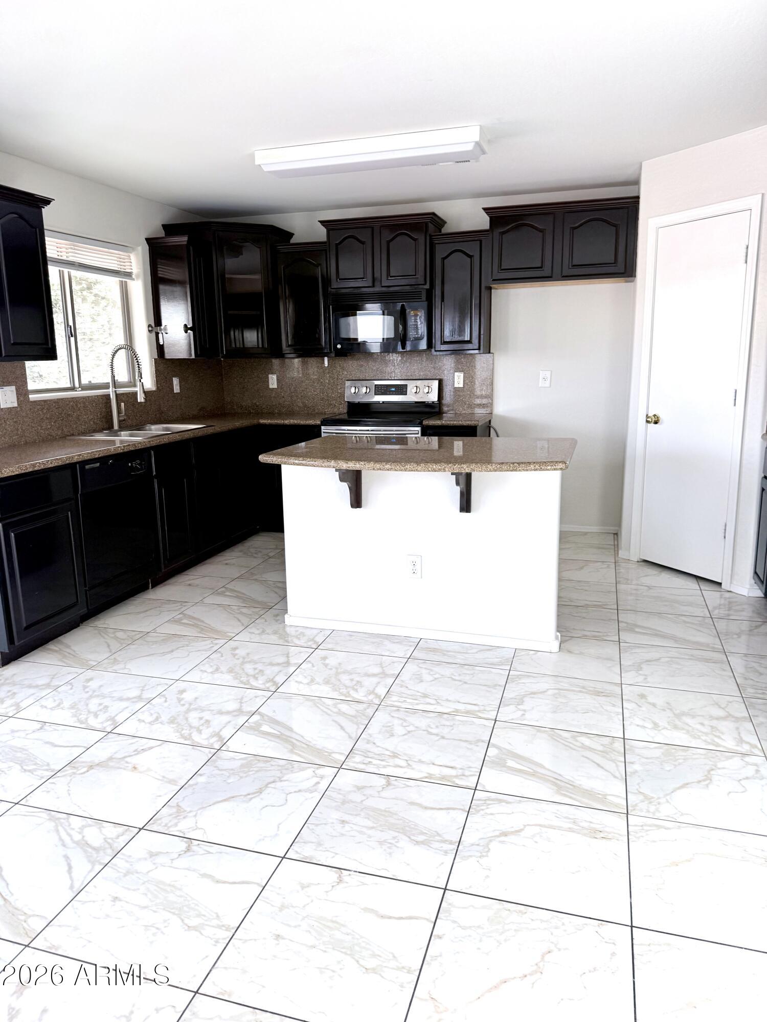 2326 West Gaby Road Phoenix, AZ 85041 - Photo 24 of 75 a kitchen with stainless steel appliances a sink a stove a microwave a sink a counter top space and cabinets