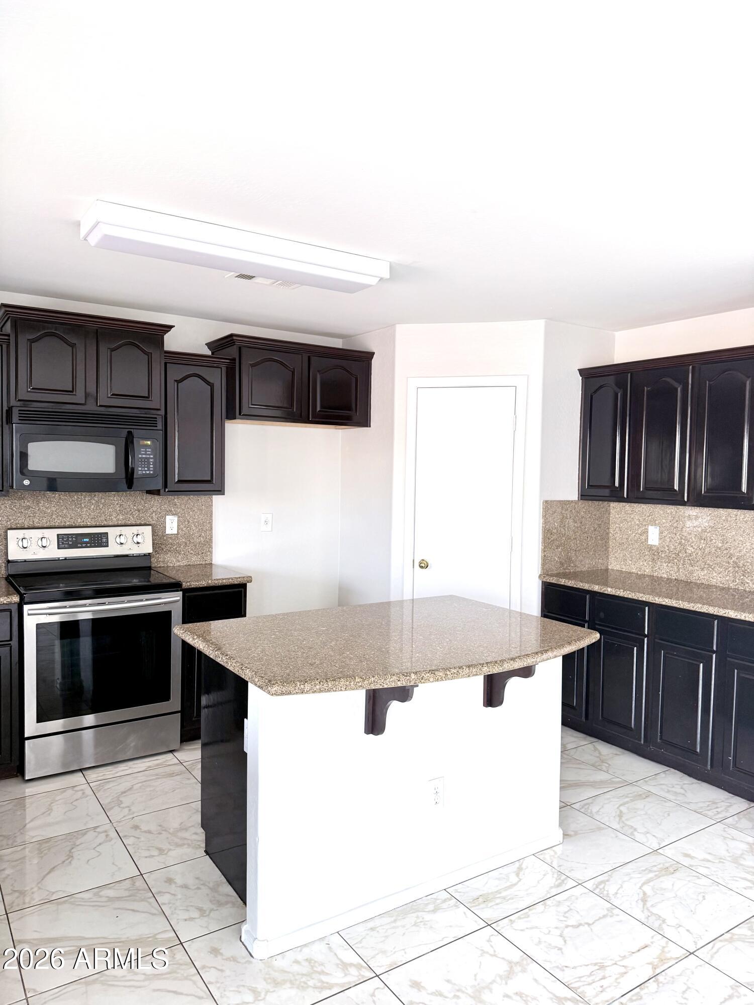 2326 West Gaby Road Phoenix, AZ 85041 - Photo 26 of 75 a kitchen with stainless steel appliances granite countertop a sink and a stove