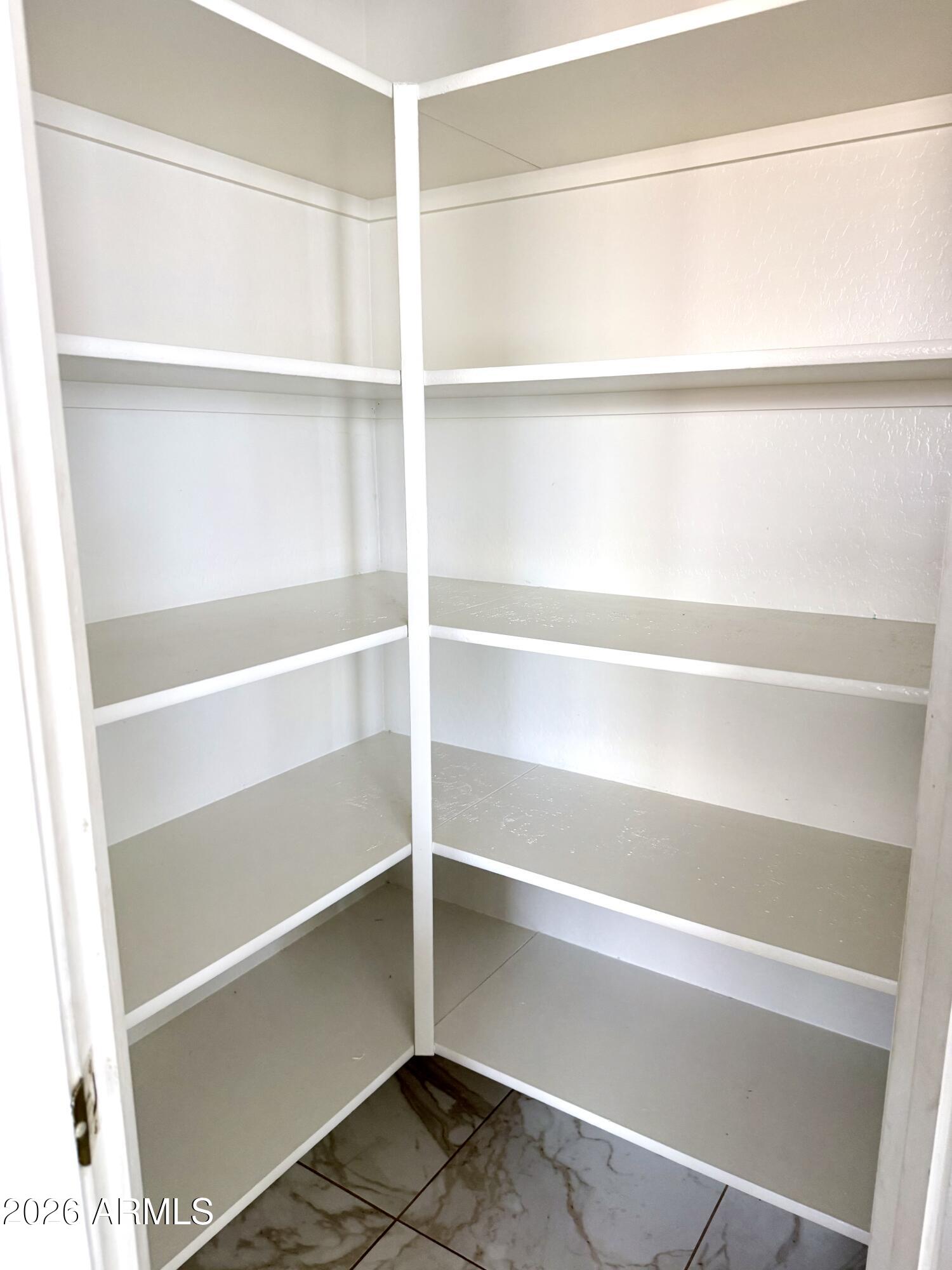 2326 West Gaby Road Phoenix, AZ 85041 - Photo 30 of 75 a view of walk in closet with empty racks
