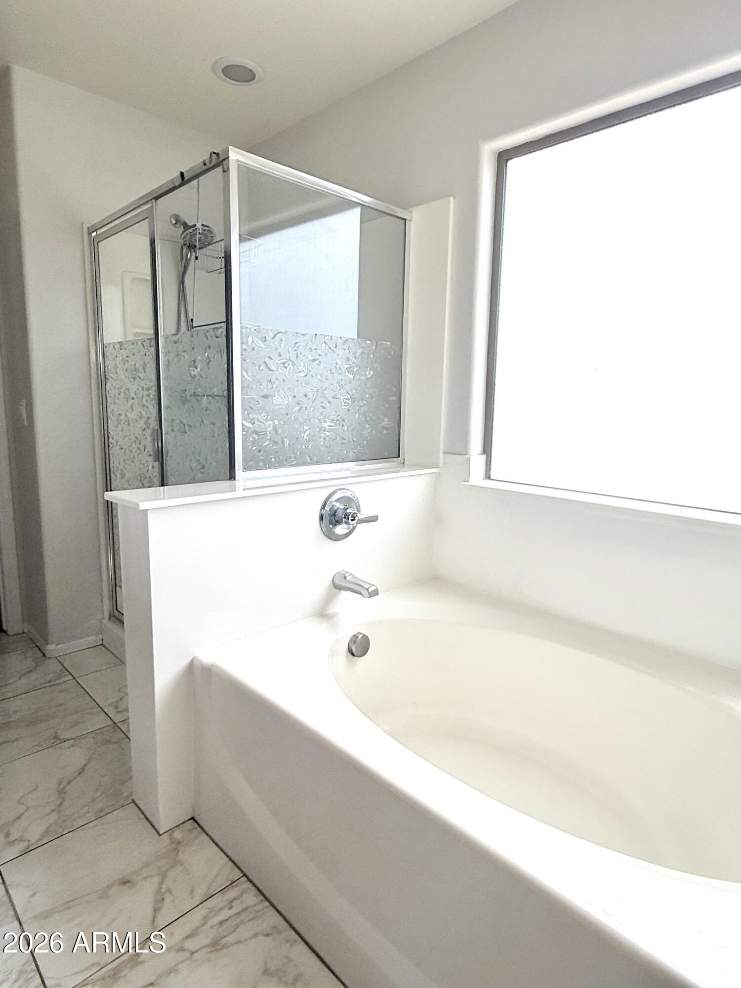 2326 West Gaby Road Phoenix, AZ 85041 - Photo 42 of 75 a bathroom with a bathtub and a shower