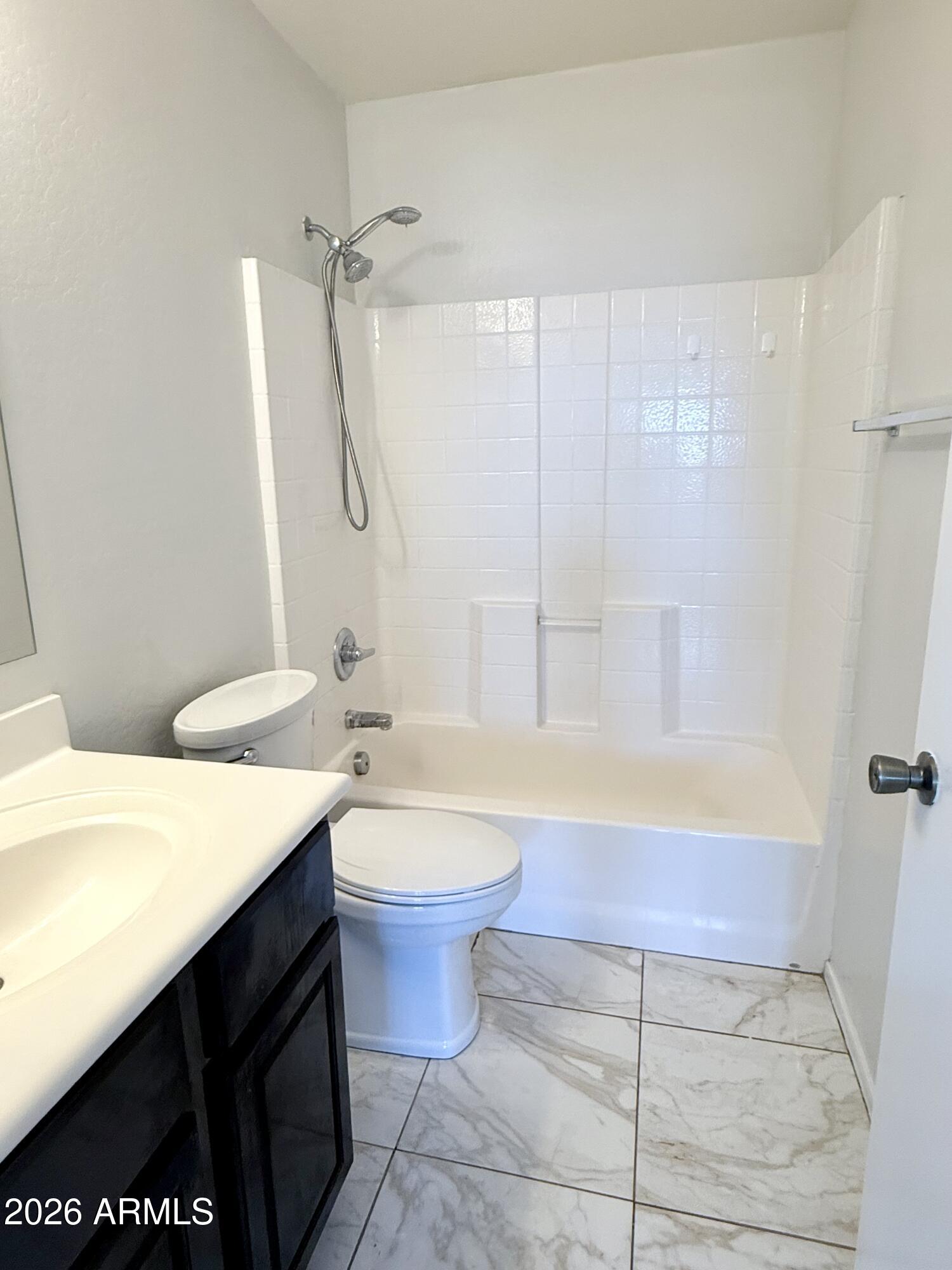 2326 West Gaby Road Phoenix, AZ 85041 - Photo 44 of 75 a bathroom with a granite countertop sink a toilet a mirror and bathtub