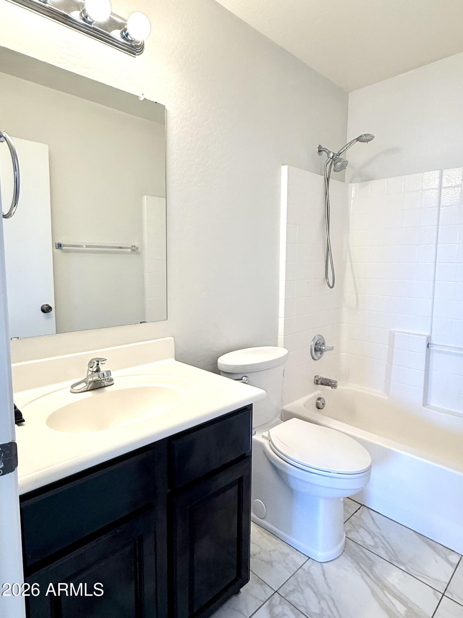 2326 West Gaby Road Phoenix, AZ 85041 - Photo 45 of 75 a bathroom with a sink toilet a mirror and shower