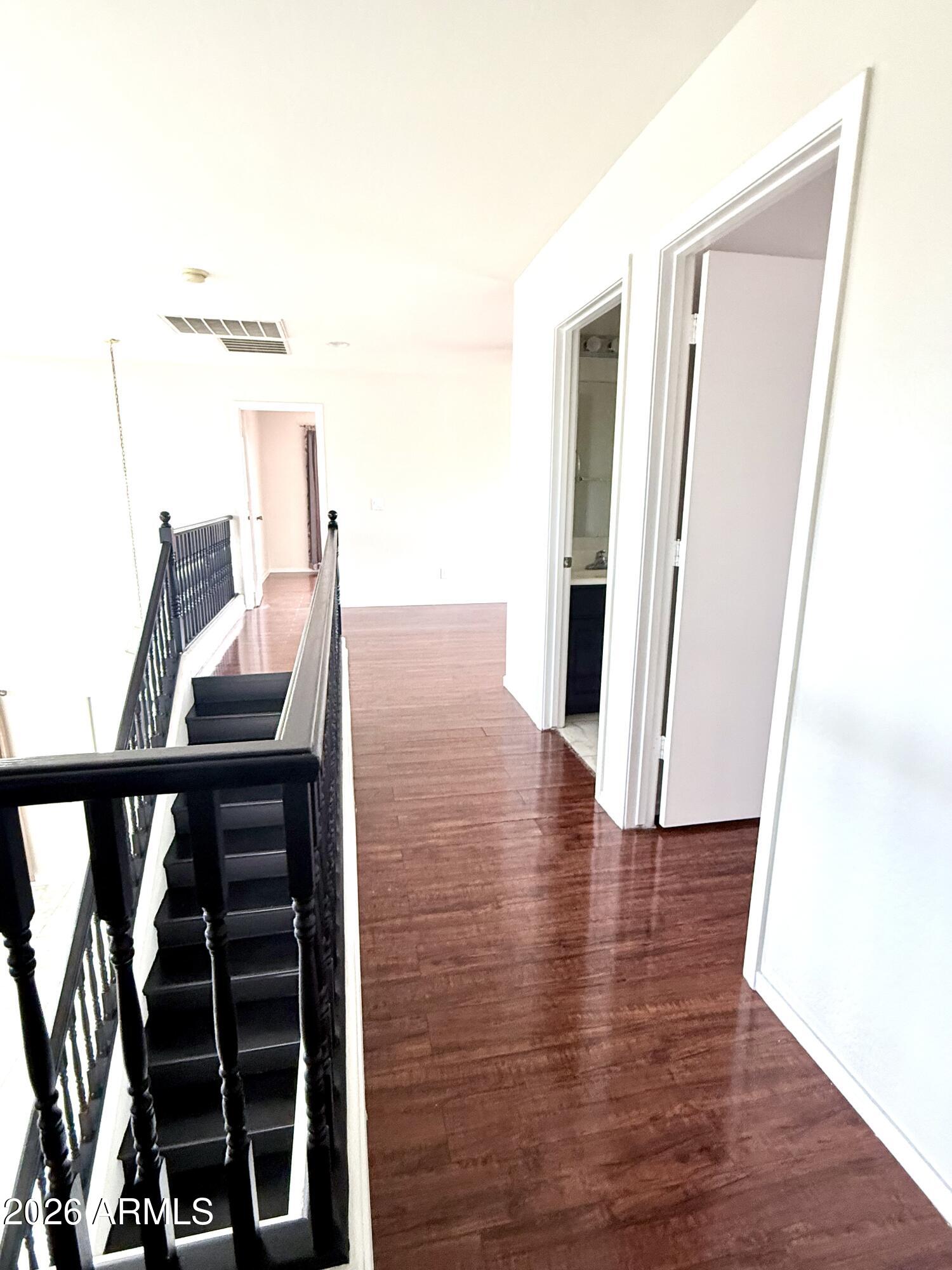 2326 West Gaby Road Phoenix, AZ 85041 - Photo 48 of 75 a view of a hallway with wooden floor and staircase