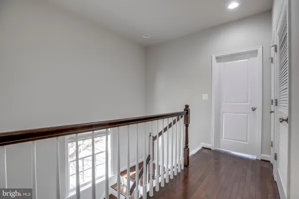 a view of a hallway with wooden floor and staircase