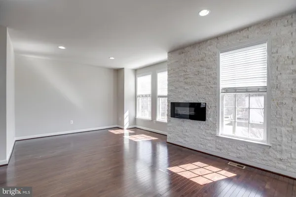 an empty room with wooden floor and fireplace