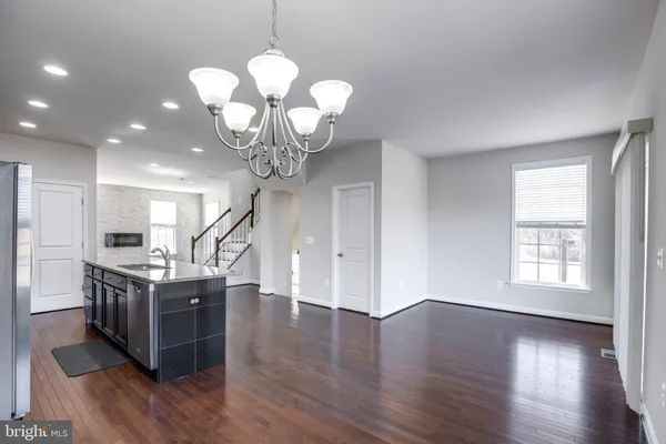 a view of a kitchen with stainless steel appliances granite countertop a stove oven and a wooden floors