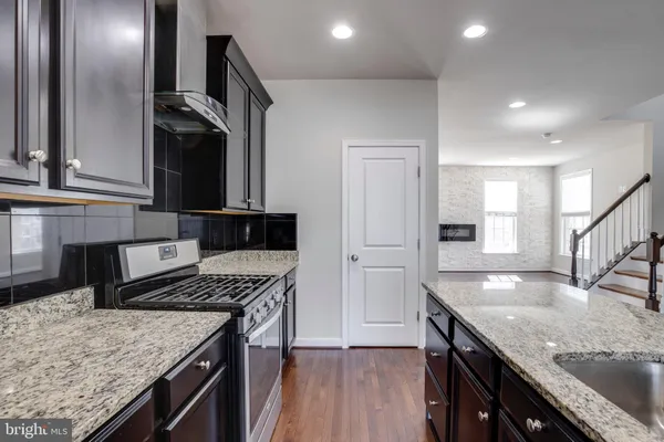 a kitchen with stainless steel appliances granite countertop a sink stove and refrigerator