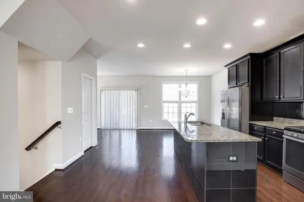 a kitchen with stainless steel appliances granite countertop a sink refrigerator and cabinets