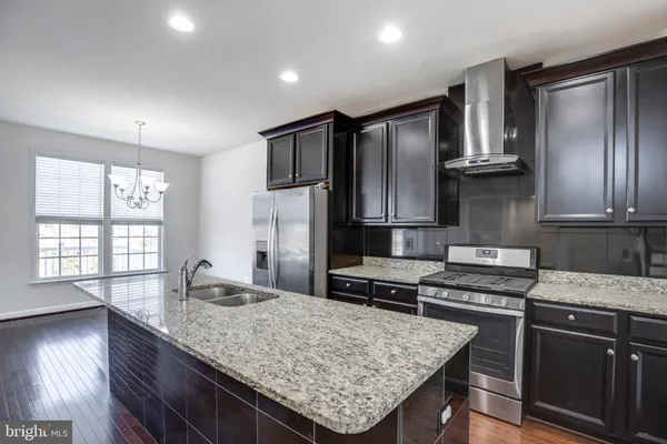a kitchen with granite countertop stainless steel appliances and wooden cabinets