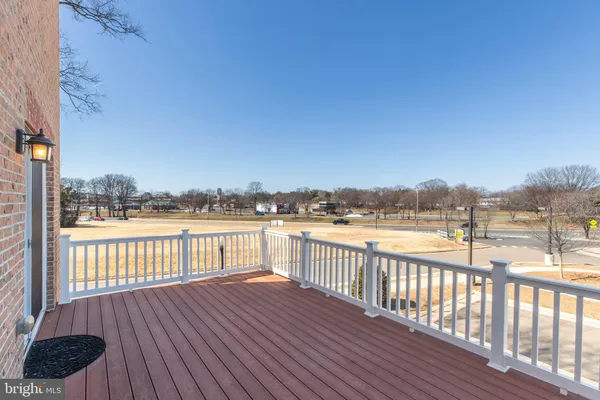 a view of a balcony with wooden floor next to a yard