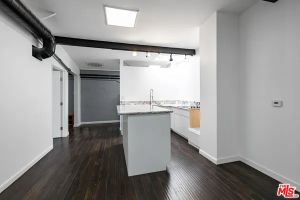 a view of a kitchen with wooden floor and a window