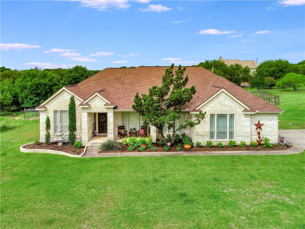 a front view of a house with a garden and trees