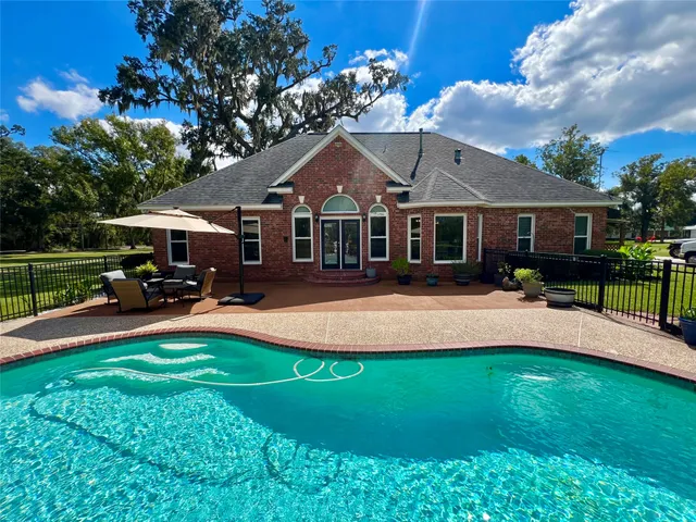a front view of a house with a garden and swimming pool