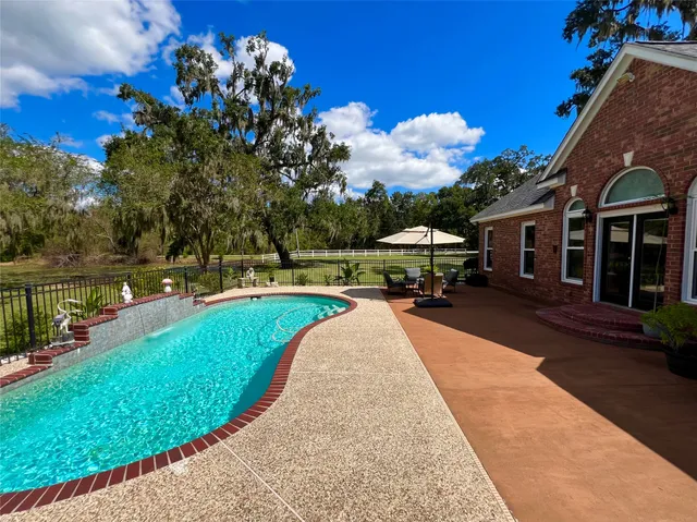 a view of a house with swimming pool and a yard
