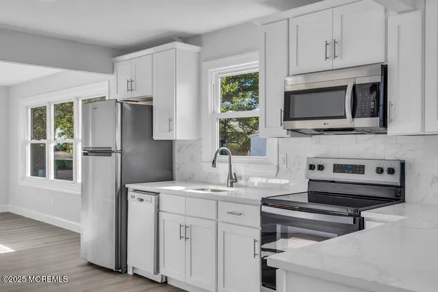 a kitchen with kitchen island a sink stainless steel appliances and cabinets
