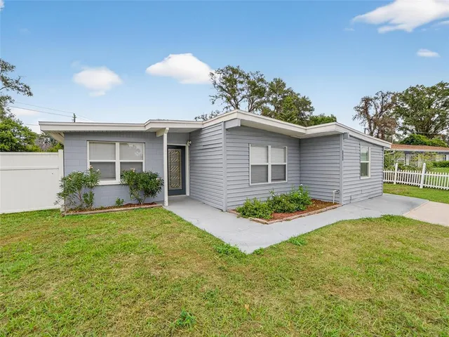 a view of a house with a yard and potted plants